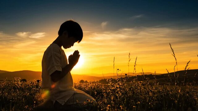 Child kneeling in prayer during the golden hour of sunset, offering a moment of tranquility and reflection.