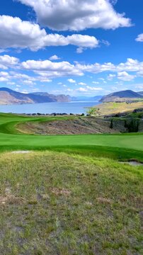 Golf Course with Mountains and Lake Clouds Blue Sky