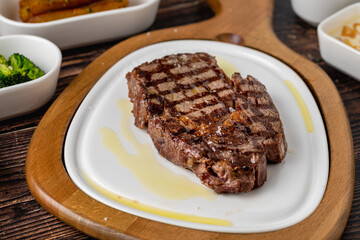Tender grilled beef steak served with olive oil on plate