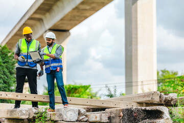 Fototapeta premium Railway engineer and technician inspecting concrete pier sections and construction debris