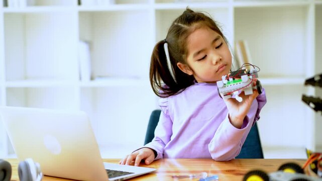 Young innovator engaged in robotics home workspace digital learning indoor setting close-up stem exploration