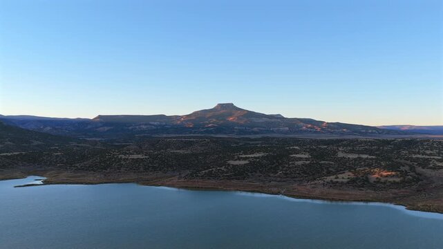 Spectacular view of a desert reservoir beneath a flat top peak. The landscape features Cerro Pedernal and Abiquiu Lake in New Mexico, famous for Georgia Okeeffe.