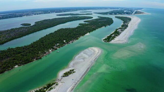 Sandbars curve through bright turquoise shallows at Stump Pass, bordered by mangrove islands and the sweeping barrier shoreline of Manasota Key along Florida&rsquo;s Gulf Coast.