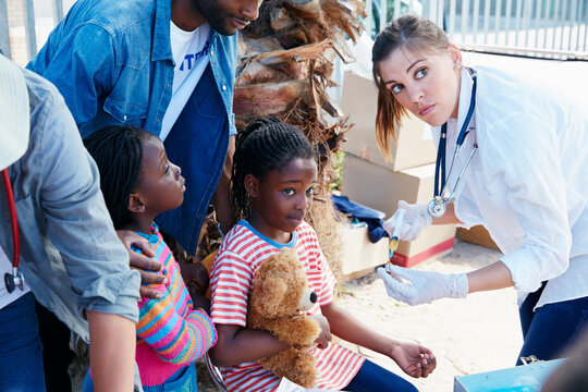 Medical, volunteer and kid outdoor with vaccine, outreach and health injection in community service. NGO, shot and team in neighborhood with medicine, child immunization or charity in pediatric care.