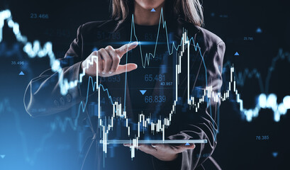 Businesswoman analyzing stock market graph with futuristic interface on dark background, representing finance, forex, and crypto concept innovation.