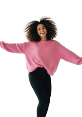 young mixed-race woman with voluminous curly hair in pastel pink knit sweater dancing joyfully in high-key studio with white cyclorama, slight motion blur, concept of positive self-expression