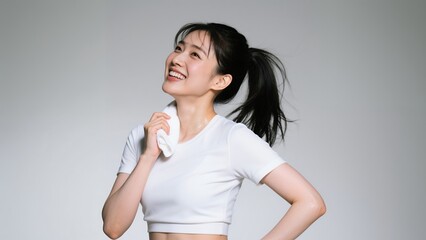 運動後にタオルで汗を拭く爽やかな笑顔の女性