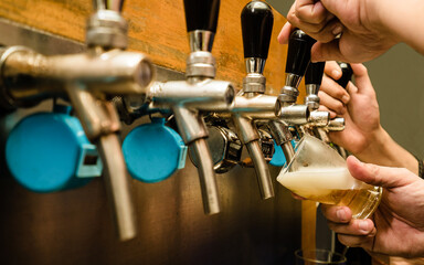 Pouring draft beer from tap into glass