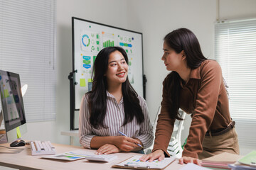 Businesswomen collaborating on sustainability project analysis in office