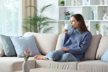 Relaxed woman in blue drinking coffee or tea
