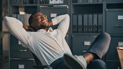 Confident young professional relaxing in a modern office, showcasing a positive work environment and success