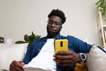 African American man receives bad news on mobile phone.
