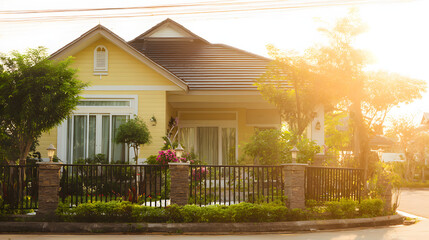 shrubbery. Charming suburban home with lush front garden bathed in warm afternoon sunlight. real-estate listings.