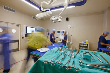 Team, surgery and blur of surgeon in hospital for medical service, emergency and procedure. Healthcare, urgency and people with tools for patient risk, medicare and collaboration in operating theater