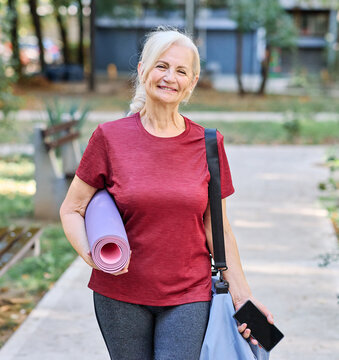 Portrait of a happy active senior woman posing after yoga class or exercising outdoors, healthy lifestyle and vitality concepts