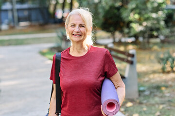 Portrait of a happy active senior woman posing after yoga class or exercising outdoors, healthy lifestyle and vitality concepts