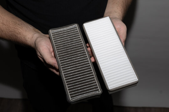 Heavily contaminated cabin air filter removed from a car, showing the need for replacement.