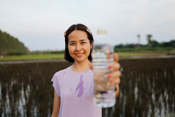 Woman drinking water after exercise.