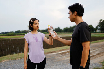 Woman and man drinking water after exercise