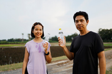 Woman and man drinking water after exercise