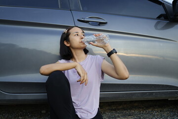 Woman drinking water after exercise.