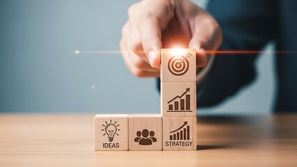 A person is placing a final wooden block with a glowing light on top of a stack representing business growth