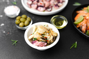 Black bowl with shrimp salad and seafood mix for tapas or gastro bar concept