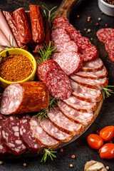 Assorted sliced sausages and meats on rustic board