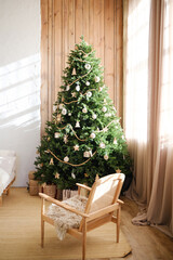 Cozy living room with decorated Christmas tree, chair with fur, and gifts beside it.