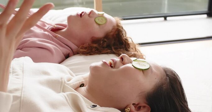 Chat is starting, pair are lying with cucumbers, tugging string, smiling by window for self care