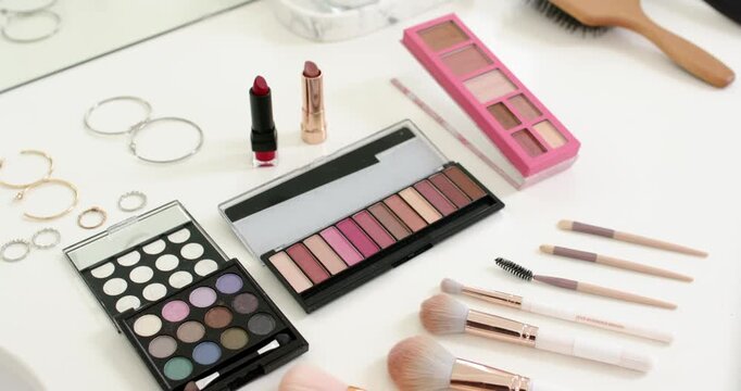 Flatlay makeup shifting as camera pushing in and adjusting focus, highlighting palettes and brushes