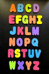 alphabet colorful foam letters on black background