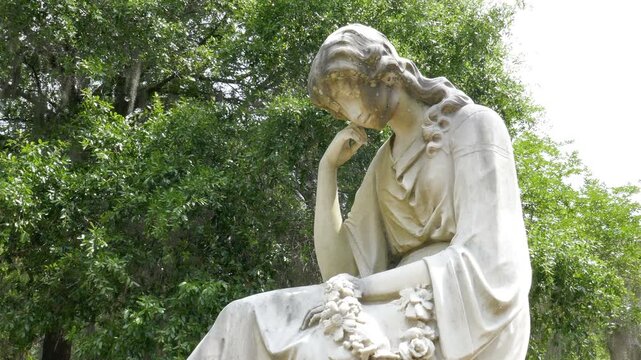 Mourning woman statue in Bonaventure Cemetery in Savannah, Georgia. The cities oldest cemetery and resting place to historic figures and hauntingly beautiful memorials.
