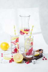Refreshing drink with lemon slices and red berries served in clear glasses with yellow striped straws