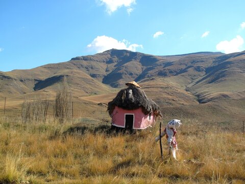 Pink rondavel and scarecrow in the Southern Drakensberg mountains of South Africa.
