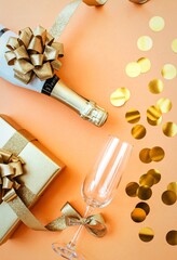 Champagne bottle gift box and empty glass with gold confetti