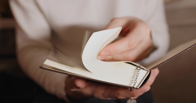 A man's hand flipping pages of a book, video included audio
