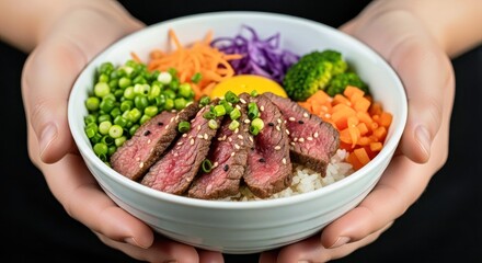 Closeup of Hands Holding a Colorful Beef and Vegetable Rice Bowl