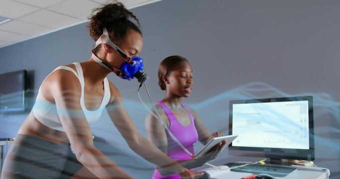 Sports lab cyclist pedaling mask tube starting test, tech using tablet, airflow measuring breathing