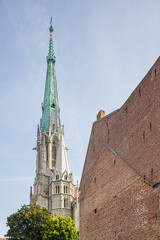 The spire of St. Mary's church in Muhlhausen seen from a back alley