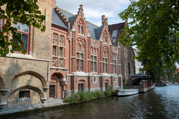 Naklejka premium Maisons historiques en briques et son canal dans la vieille ville médiévale de Bruges, Belgique. Province de Flandre occidentale, Belgique. Paysage urbain de Bruges.