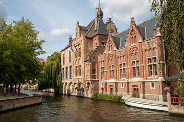 Fototapeta premium Maisons historiques en briques et son canal dans la vieille ville médiévale de Bruges, Belgique. Province de Flandre occidentale, Belgique. Paysage urbain de Bruges.
