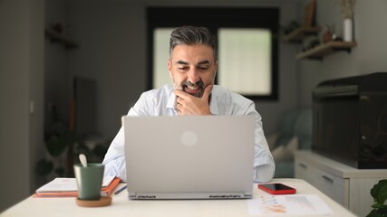 Mature man working remote using laptop for video call
