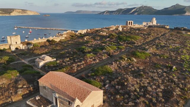 Methoni,Messenia,Peloponnese,Aerial view forward over Methoni Castle towards the sea,circle pan left around the Castle tower.Background are hills and beautiful landscape during golden hour.