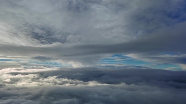 An immersive dreamlike cloudscape recorded from a jet cockpit flying at supersonic speed between endless layers of ethereal straus clouds illuminated by the sunset difuse light. Ultra-realistic 4K