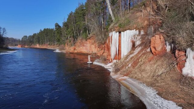 Sandstone cliffs with a icefall by the Salaca River in Latvia.