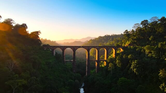 Scenic Aerial View of the Nine Arch Bridge in Sri Lanka at Sunrise with Misty Mountains and Lush Green Landscape