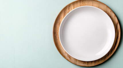 Empty white ceramic plate on wooden charger with pastel background, minimal still life calm