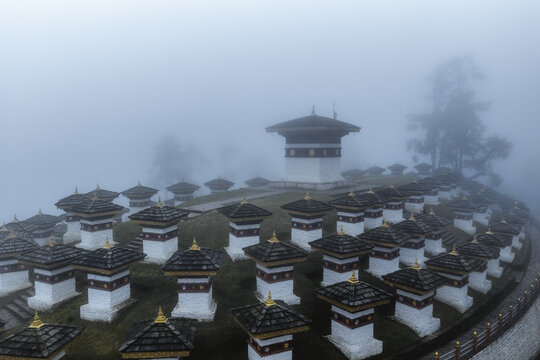Aerial view of stupas pierce the dense fog at Druk Wangyal Chortens, Dochula Pass, Bhutan.
