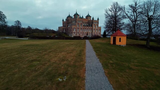 Aerial view of the grand Stora Sundby Castle with its elaborate architecture and a small yellow outbuilding on the lawn, Stora Sundby, Sodermanlands lan, Sweden.